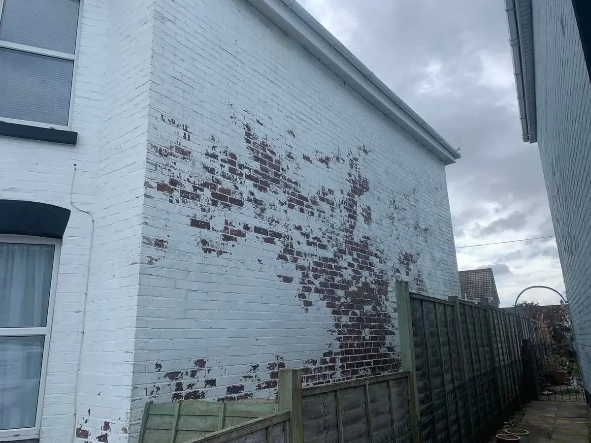 Peeling paint on a brick wall before redecoration in Mousehole