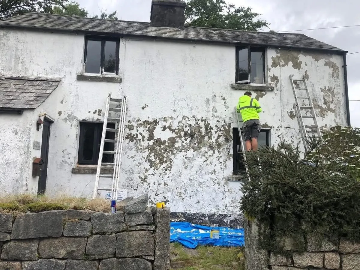 Cottage with blown, flaking render before repair in Mousehole